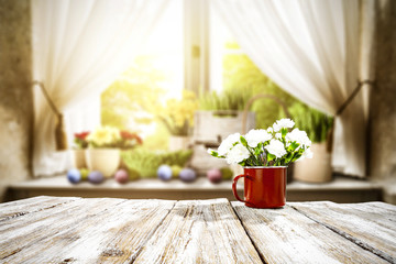 Wooden table of free space for your decoration. Spring window background. Easter eggs and flowers on window sill. 