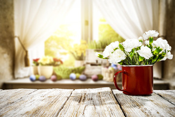 Wooden table of free space for your decoration. Spring window background. Easter eggs and flowers on window sill. 