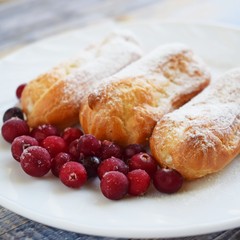 Custard tarts and fresh berries on a white plate.