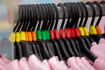 Close up of a clothing rack with hangers showing different clothing size tags