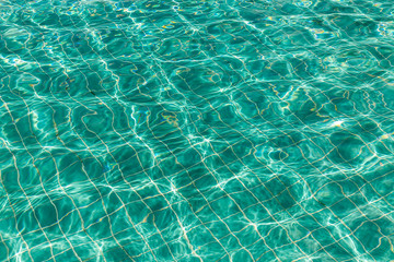 Background of rippled pattern of clean water in a blue swimming pool.
