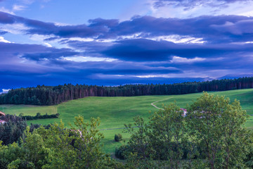 Alpe di Siusi, Seiser Alm with Sassolungo Langkofel Dolomite, a large green field with trees in the background