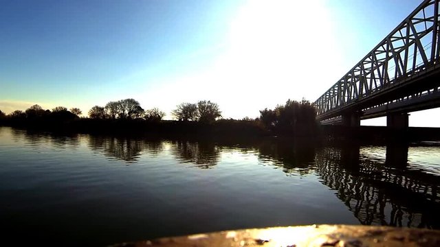 A boat ride on a river by a bridge in rural Japan.