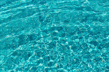 Background of rippled pattern of clean water in a blue swimming pool.