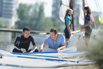 young men on shore preparing to go on paddle board