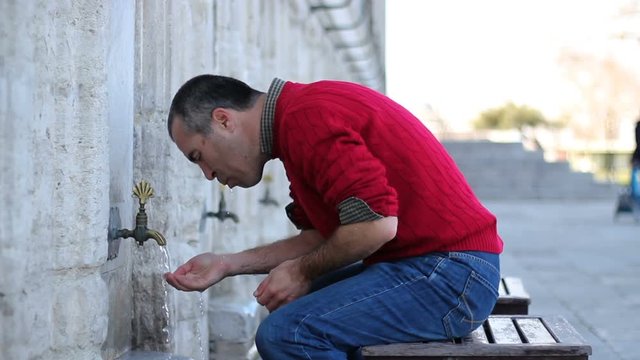 Muslim man taking ablution for prayer