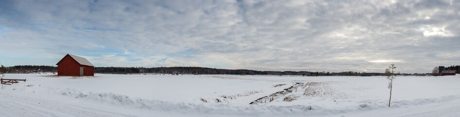 Snowy field panorama with red barn © Juha Tuomimaki