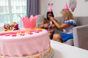 pink cake of a little princess with a crown and animal figures. Birthday one year old. holiday concept.