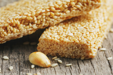Assorted kozinaki, on old vintage background, with burlap fabric. Country style. Delicious sweets from the seeds of sunflower, sesame and peanuts, covered with shiny glaze.