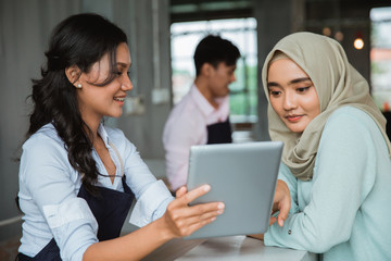 a hijab woman order food and drink to waitress in the cafe