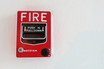 a red fire notifier on the white wall