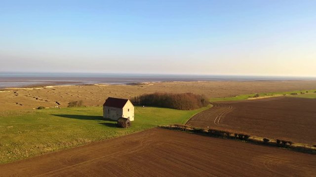 Aerial sequence featuring The Chapel of St Peter-on-the-Wall, Bradwell-on-Sea, Essex. It is a Grade I listed building and among the oldest largely intact Christian churches in England, built in 660.