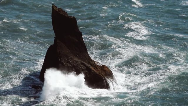 Aerial view of a stunning rock in Reynisfjara, Iceland, whitch waves crashing on the rock.
