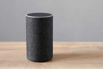 smart speaker virtual assistant for smart home on desk - gray background with copy space