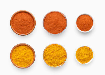 Different sized bowls with paprika and turmeric powder on white