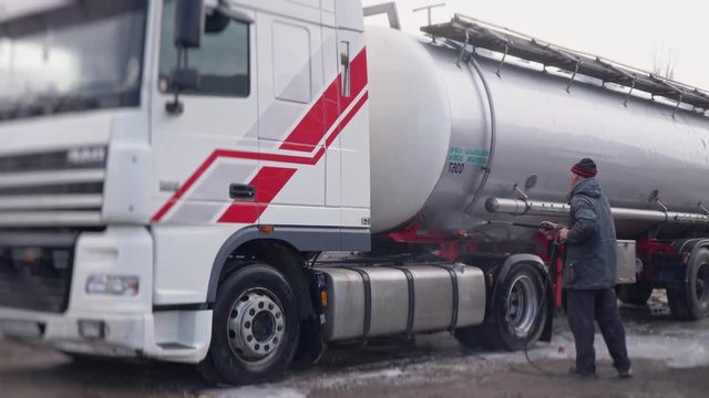 Worker carefully washes a truck with a chester