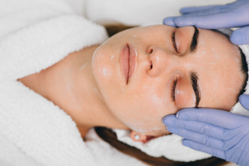 Obraz na płótnie Canvas woman receiving facial treatment at beauty salon. Exfoliation