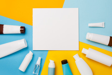 Mock up summer skin care cosmetics on yellow and blue background. White bottles of woman cosmetics on yellow. Summer holidays or vacation. Preparation for summer care. Sunscreen protection  products