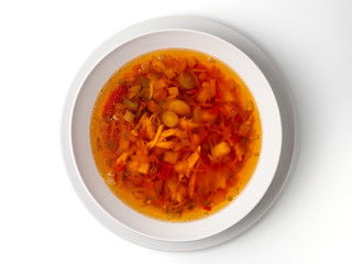 Bowl with chicken, beetroot and other vegetables soup. Perfect bright broth in italian minestrone style, isolated on white. Top view or flat lay.