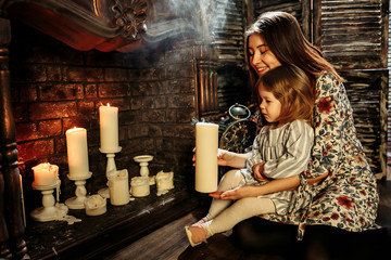 Studio photo of mom and daughter near a fireplace