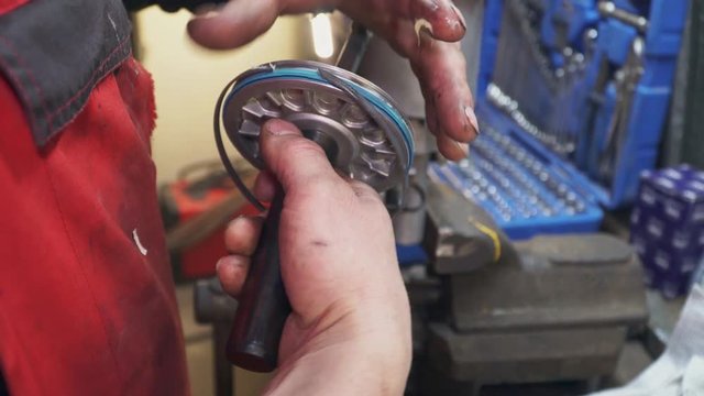 A mechanic repairs a part for a truck