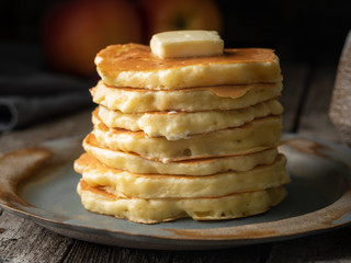 Pancake with butter, macro, close-up. Dark moody old rustic wooden background.