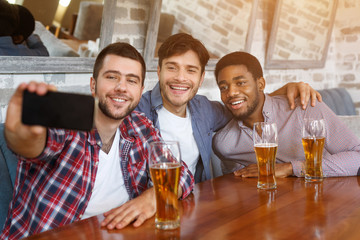 Friends making selfie and smiling, resting at pub