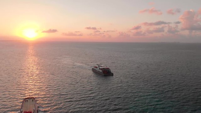 Aerial footage of a passenger and car ferry that goes between Isla Mujeres and Cancun in Mexico at sunrise.