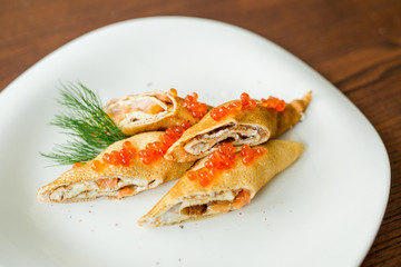 pancakes rolls with salmon and red caviar