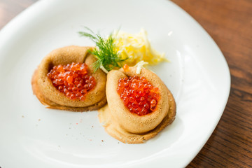 fresh pancakes with red caviar and oil