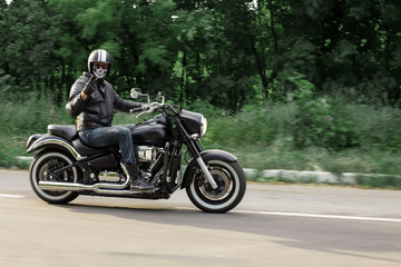 Obraz na płótnie Canvas slow motion, biker riding unknown motorbike with blur movement, speed concept