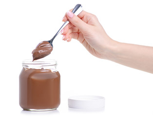 A jar of chocolate spread, spoon in hand on white background isolation