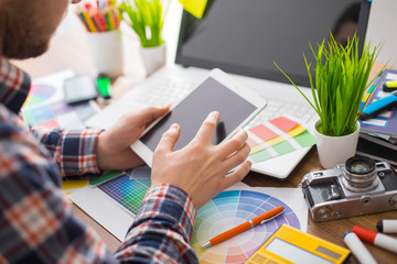 Young Handsome Graphic designer using graphics tablet to do his work at desk