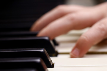 Fototapeta premium Antique piano keys and blurred fingers in background.