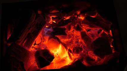 red fire burns wood in dark, ash in fire, close-up. hot coals for brazier