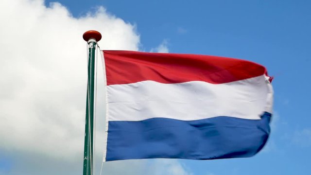 Slow motion of dutch flag blowing in a blue sky