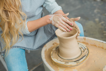 girl makes a jug of his own hands in a pottery workshop	