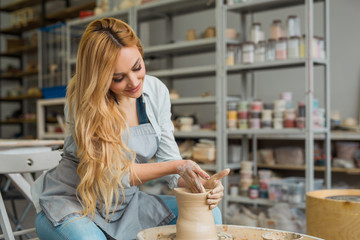 beautiful young girl makes a jug of clay with their own hands