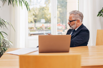 Fototapeta premium Senior businessman at work in his office