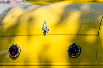 Close-up of a yellow roadster's trunk lid and tailights