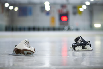 Figure Skates and Hockey Skates on Ice Rink - obrazy, fototapety, plakaty