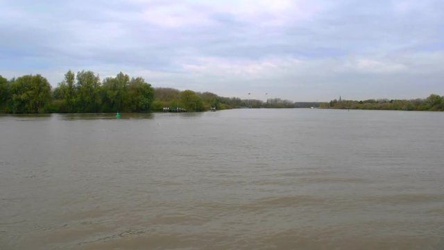 Time lapse of boats and a small ferry service on the Schelde river in St. Amands Belgium