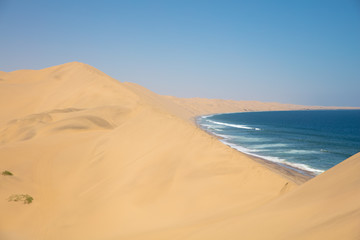 Fototapeta na wymiar Sandwich Harbour and the stunning dunes in Namibia during the Summer.