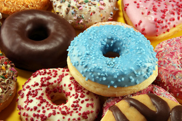 assorted donuts with chocolate frosted, pink glazed and sprinkles donuts