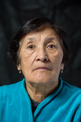 portrait of an elderly thoughtful woman on a dark background