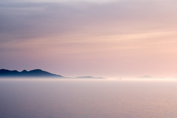 Fototapeta na wymiar Sunlit fog on a coastline