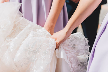 Bridesmaids helping a bride with her wedding dress