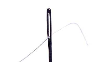 Sewing needle and thread on a white background. Macro of a needle's eye and thread.