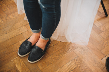 Bride in the morning of her wedding before changing into her wedding dress wearing jeans
