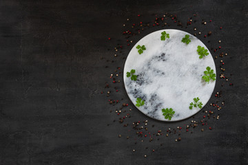 Condiments and spices on round stone board. Top view, close-up on vintage wooden background